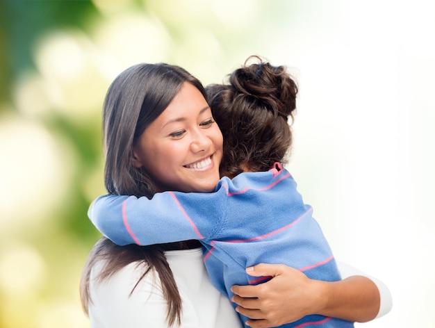 concept de famille, d'enfants, d'amour et de personnes heureuses - heureuse mère et fille étreignant sur fond vert