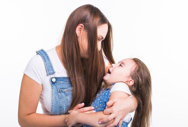 Concept de famille, enfants et maternité - jeune mère et sa jeune fille passent du temps ensemble isolé sur une surface blanche