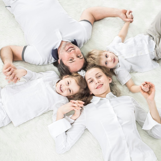 Concept de famille heureuse famille heureuse reposant sur le tapis le dimanche