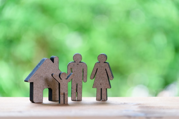 Concept de famille heureuse, modèle en bois père, mère et enfant avec la nature verte