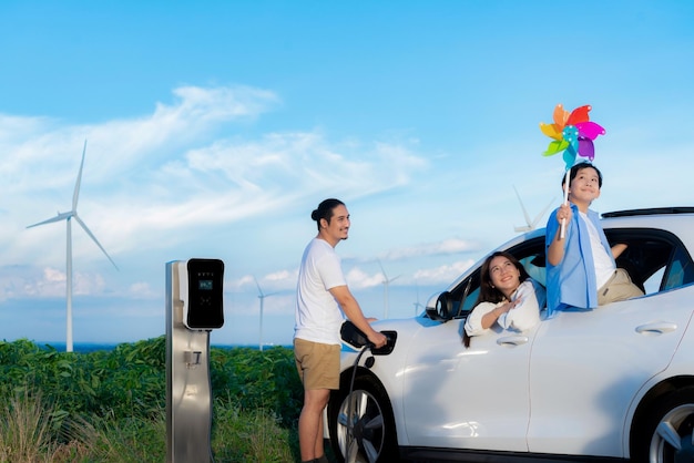 Concept de famille heureuse progressive à l'éolienne avec véhicule électrique