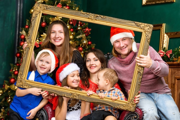 Concept de famille de Noël de bonheur - grande maison de famille souriante en chapeaux de Santa Helper