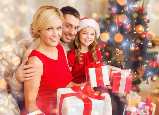 concept de famille, Noël, Noël, hiver, bonheur et personnes - famille souriante dans des chapeaux d'assistant de père Noël avec de nombreuses boîtes-cadeaux