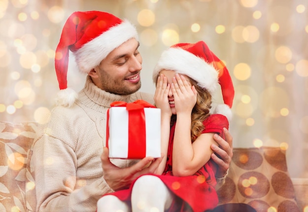 concept de famille, noël, noël, hiver, bonheur et personnes - fille souriante aux yeux fermés attendant un cadeau de fathe