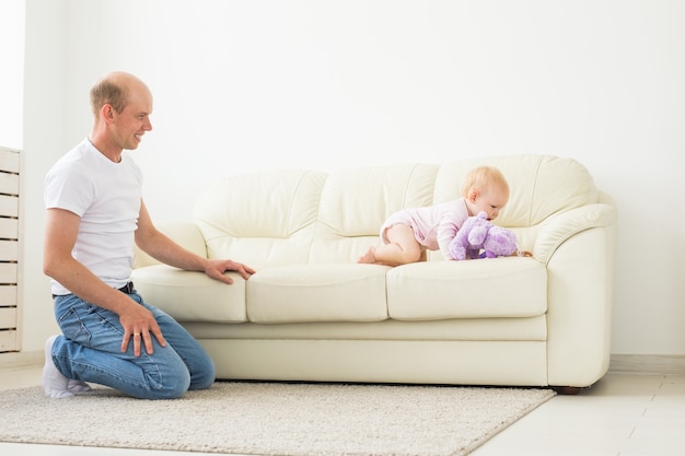 Concept de famille, parentalité et paternité - heureux père jouant avec petite fille à la maison