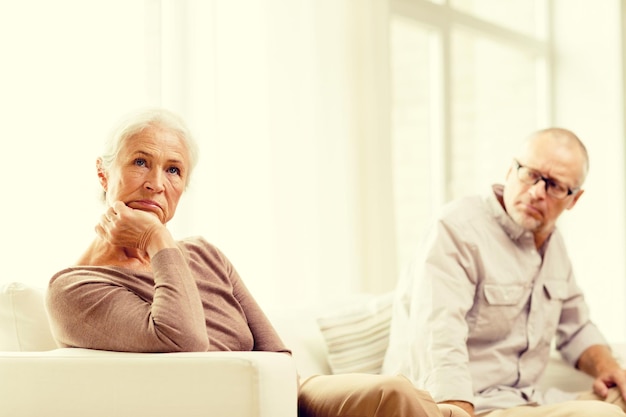 Concept De Famille, De Relations, D'âge Et De Personnes - Couple De Personnes âgées Assis Sur Un Canapé à La Maison