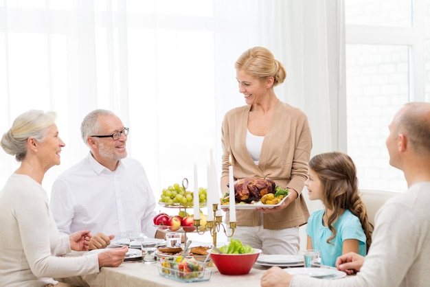 concept de famille, de vacances, de génération et de personnes - famille souriante en train de dîner à la maison