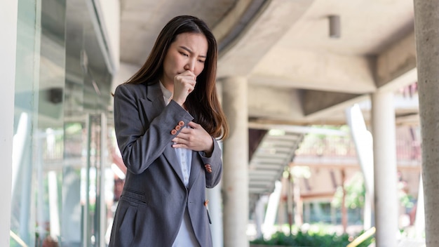 Concept de femme qui travaille une femme qui tousse après avoir été en contact avec de nombreuses personnes tout en travaillant sans aucune protection.