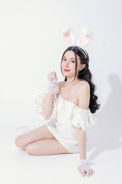 Concept de festival d'ester Une femme asiatique mignonne a un joli visage se sent heureuse d'avoir une peau fraîche et claire parfaite et un corps mince avec des oreilles de lapin moelleuses sur fond blanc isolé