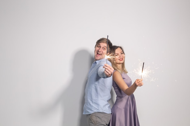 Concept De Fête Et De Célébrations De Personnes Jeune Couple Avec Des Cierges Restant Dos à Dos Sur Un Mur Blanc