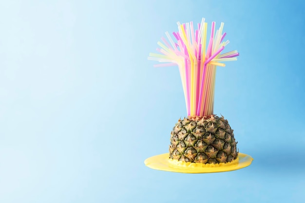 Concept de fête d'été créatif sur fond bleu avec espace de copie Ananas fondant avec des pailles à cocktail