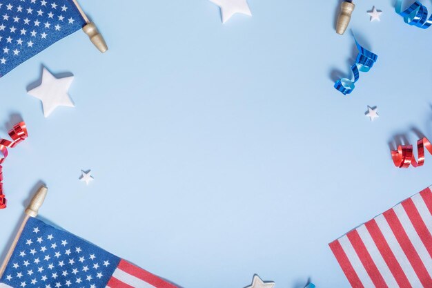 Concept de la fête de l'indépendance des États-Unis Drapeaux des États-Unis et spirales rouges et bleues et étoiles blanches vue de dessus à plat sur fond bleu avec espace de copie