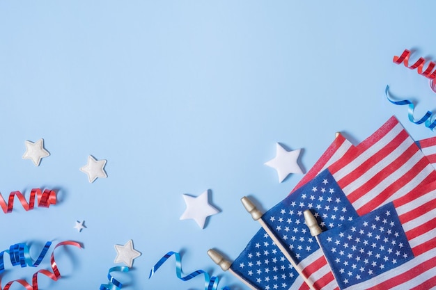 Concept de la fête de l'indépendance des États-Unis Drapeaux des États-Unis et spirales rouges et bleues et étoiles blanches vue de dessus à plat sur fond bleu avec espace de copie