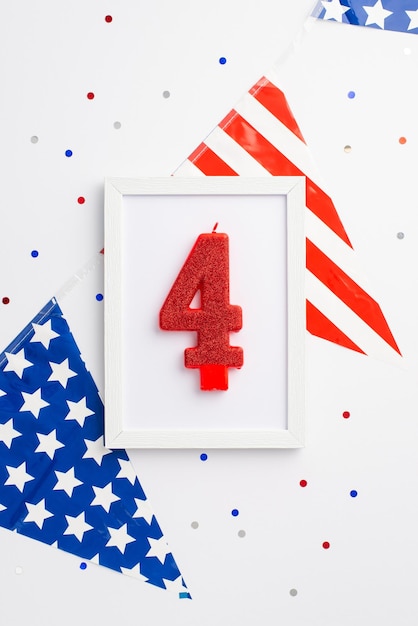 Concept de la fête de l'indépendance des États-Unis Vue de dessus photo verticale du cadre photo avec guirlande de drapeau national bougie numéro 4 et confettis sur fond blanc isolé