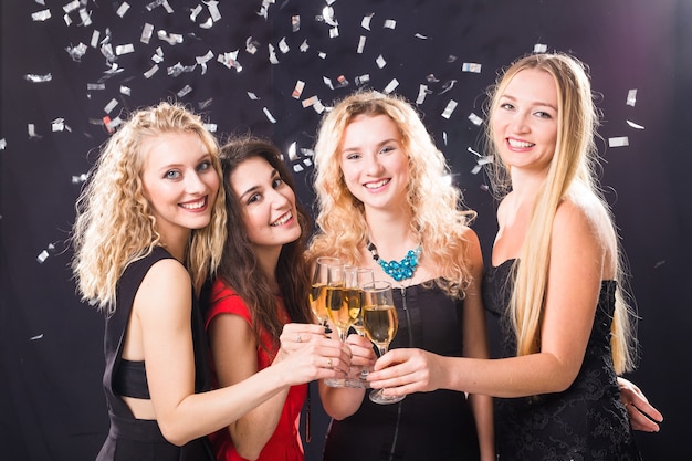 Concept de fête, vacances, célébration et nouvel an - Joyeuse jeune femme trinquant de champagne à la fête.