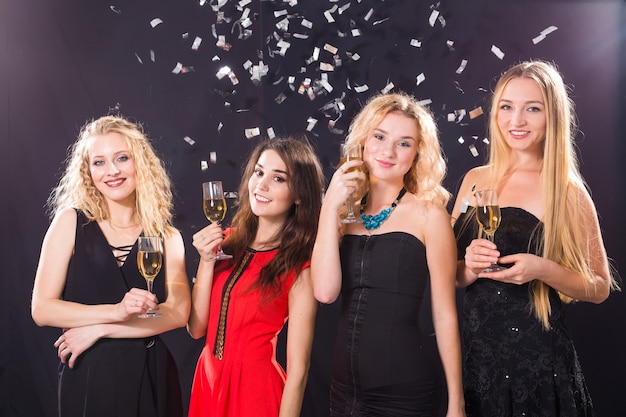 Concept de fête, vacances, célébration et vie nocturne - amies souriantes avec des verres de champagne en club.