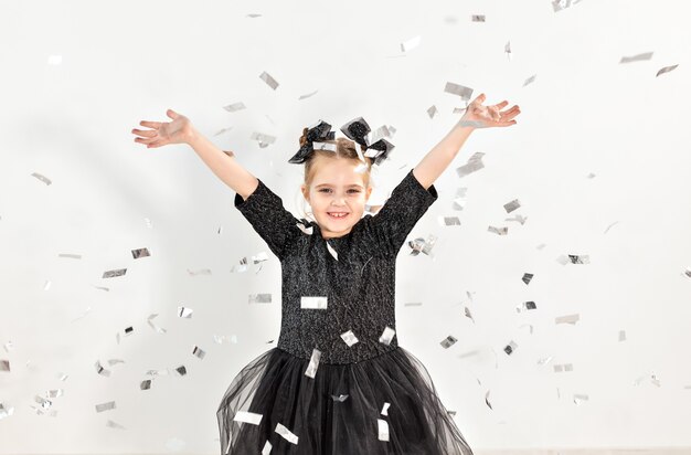 Concept de fête, vacances, nouvel an et célébration - Enfant de sexe féminin jetant des confettis.