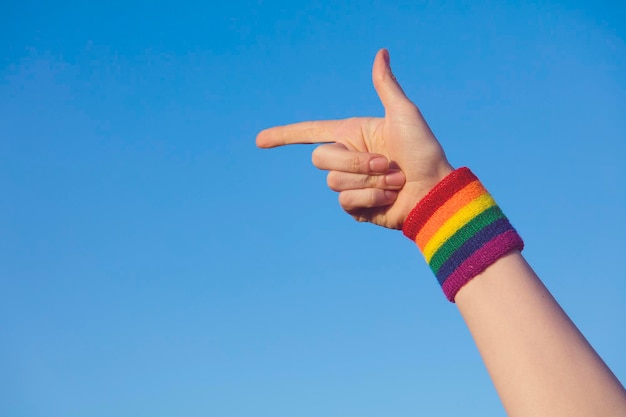 Concept de fierté gay Pointant la main avec le bracelet drapeau arc-en-ciel LGBT de la fierté gay