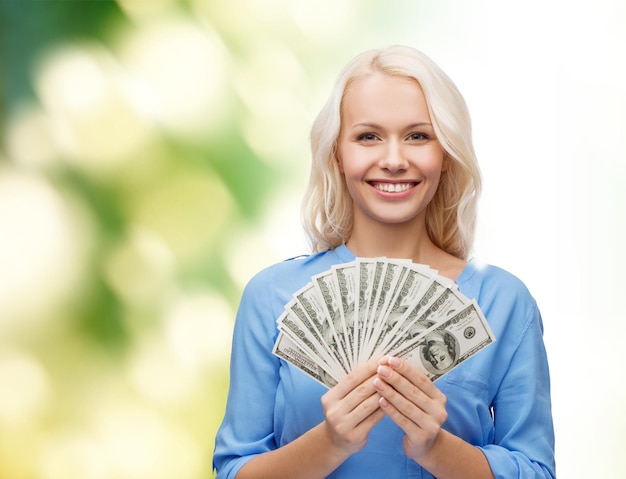 Photo concept des finances et des personnes - femme souriante en robe rouge avec de l'argent en dollars américains