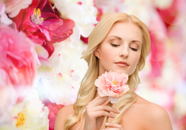 concept floral et beauté - jolie femme avec fleur de pivoine