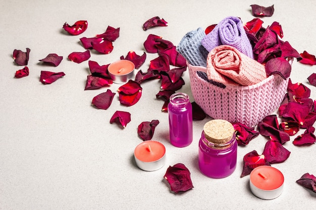 Concept floral et spa avec pétales de roses séchées, bougies parfumées et serviette douce