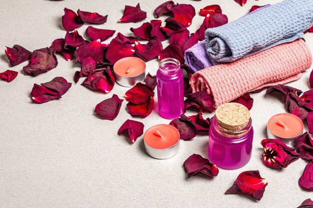 Concept floral et spa avec pétales de roses séchées, bougies parfumées et serviette douce