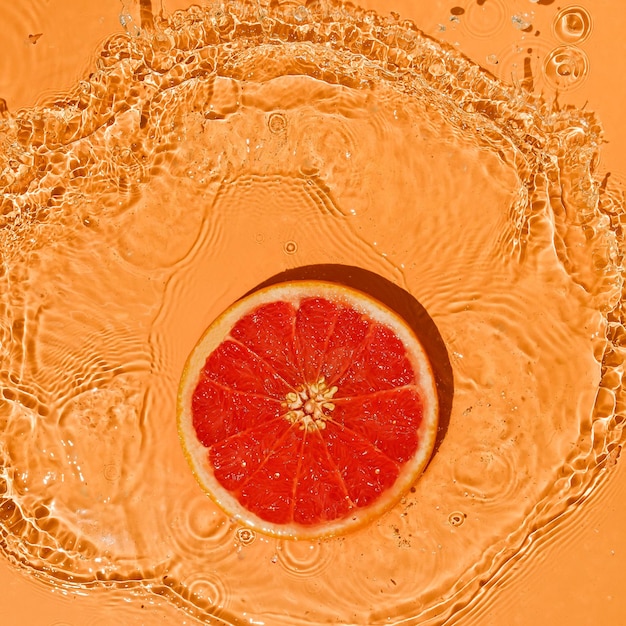 Concept de fruits d'été pamplemousse rouge agrumes sur un fond orange vif avec des touches