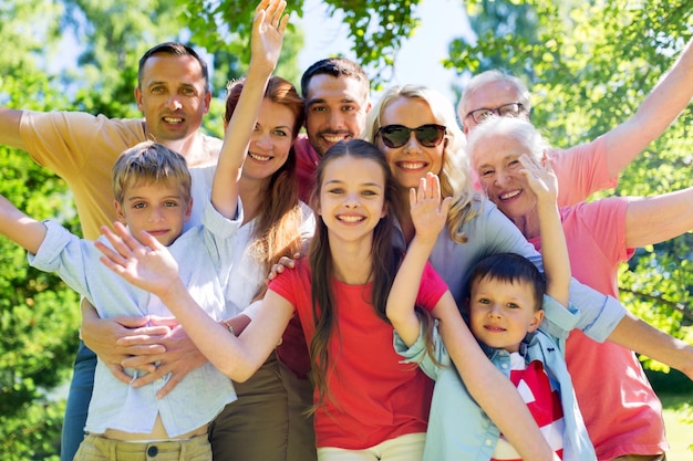 Photo concept de génération et de peuple - portrait de famille heureuse dans le jardin d'été