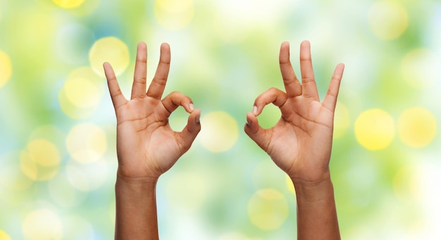 concept de geste, de personnes et de parties du corps - femme africaine deux mains montrant le signe ok sur fond bleu ciel et nuages