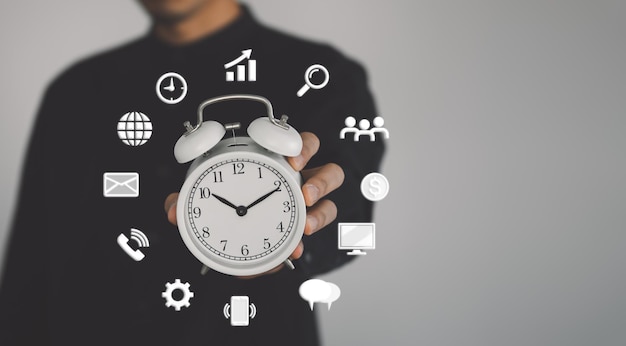 Photo concept de gestion du temps l'homme d'affaires tient l'horloge et l'icône gestion du travail