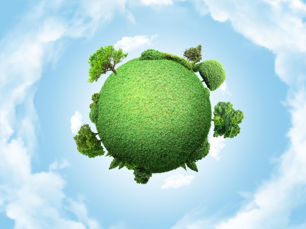 Concept globe miniature montrant l'environnement avec des arbres et de l'herbe sur fond de ciel nuageux