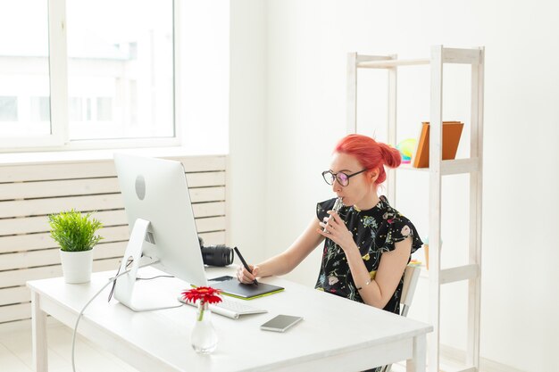 Concept De Graphiste - Femme Graphiste Travaillant Sur Ordinateur Tout En Utilisant Une Tablette Graphique Au Bureau Au Bureau Et Fumant Une Vape.