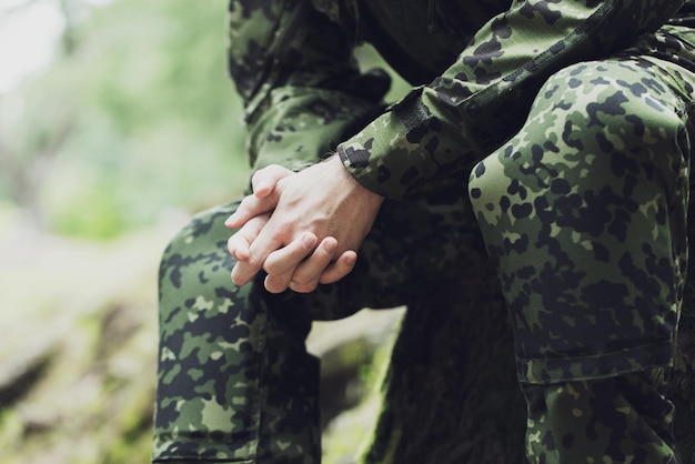 concept de guerre, d'armée et de peuple - gros plan d'un jeune soldat en uniforme militaire