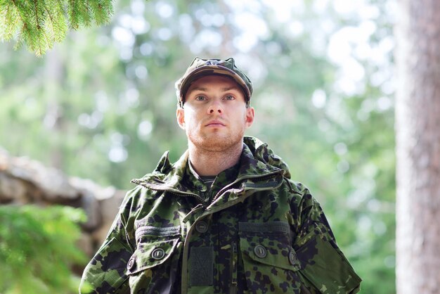 concept de guerre, d'armée et de peuple - jeune soldat ou ranger portant l'uniforme militaire en forêt