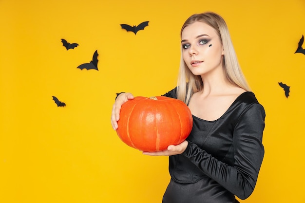 Concept d'Halloween jeune femme sur fond jaune