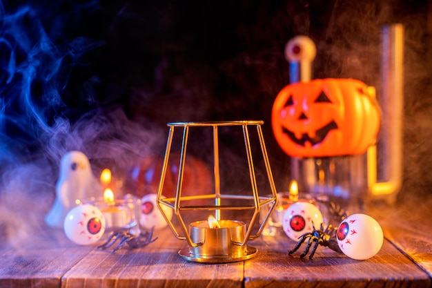 Concept d'Halloween lanterne de citrouille orange et bougies sur une table en bois sombre avec de la fumée bleue orange autour de l'arrière-plan truc ou friandise en gros plan