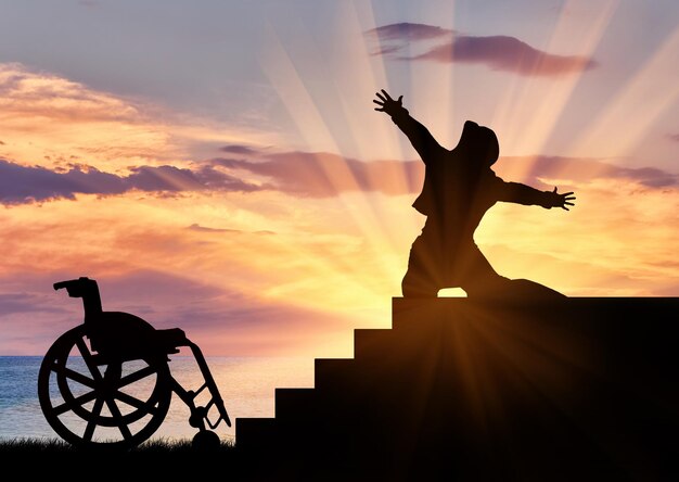 Concept de handicap et positif. Silhouette de personne handicapée pour faire l'expérience du bonheur en haut des escaliers au coucher du soleil