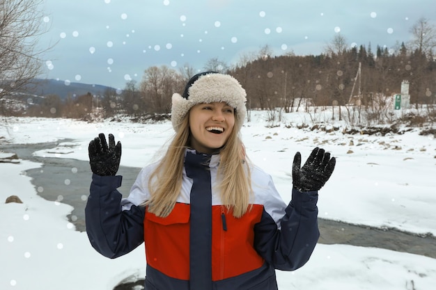 Concept de l'heure d'hiver jeune femme au chapeau avec oreillettes en plein air