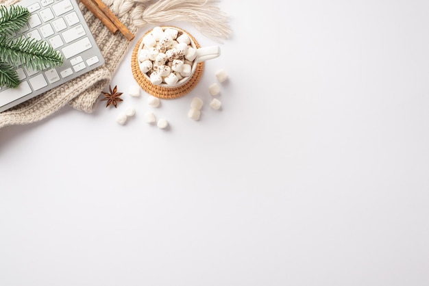 Concept d'hiver Photo vue de dessus d'une tasse de clavier de boisson chaude dispersée branche de pin de guimauve bâtons de cannelle anis et plaid tricoté confortable sur fond blanc isolé