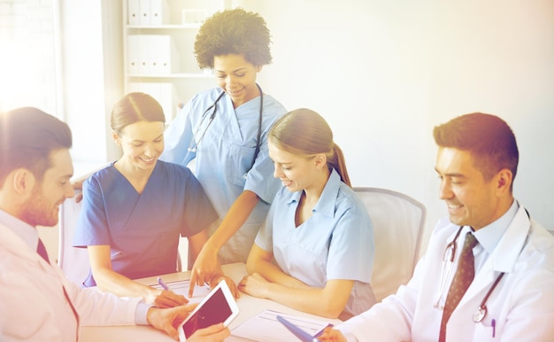 Photo concept d'hôpital, d'éducation médicale, de soins de santé, de personnes et de médecine - groupe de médecins heureux avec des ordinateurs tablettes se réunissant au cabinet médical