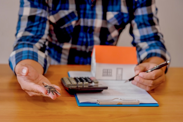 Concept immobilier d&#39;entreprise, modèle de maison sur fond en bois et flou.