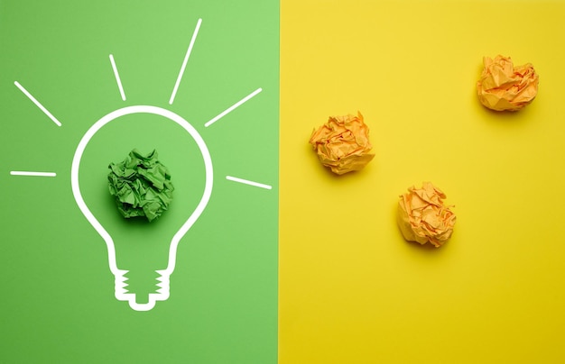 Le concept d'inspiration avec de nouvelles idées la recherche de solutions créatives feuilles de papier froissées sous forme de boules sur fond jaune vert