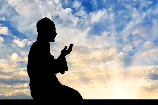 Le concept de l'Islam est la religion. Silhouette d'homme priant au coucher du soleil