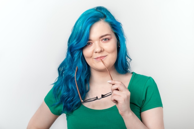 Concept de jeunesse, d'élégance et de mode - Belle jeune femme aux cheveux bleus et lunettes sourit