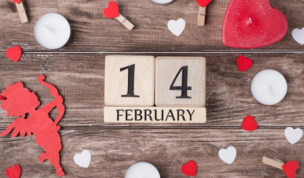 Concept de jour de saint valentin heureux. En haut au-dessus des frais généraux vue rapprochée photo de calendrier en bois et de beaux accessoires tendres sur un bureau rustique rétro