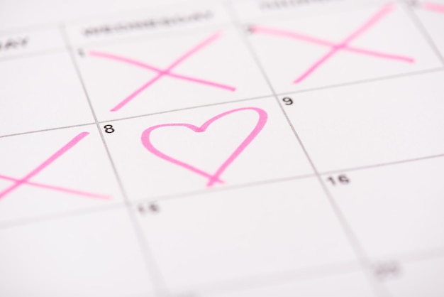 Concept de la journée de la femme heureuse. Photo en gros plan d'une cellule de calendrier et d'un coeur rose dessiné dessus