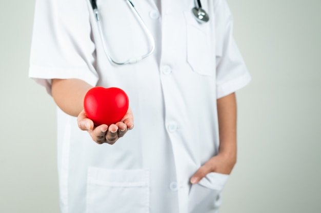 Concept de journée mondiale du cœur de femme médecin main tenant coeur rouge