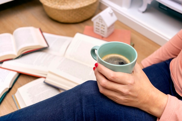 Concept de la Journée mondiale du livre Jeune fille buvant du café en lisant des livres