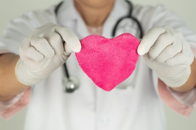 Concept de la journée mondiale de la santé cardiaque et assurance médicale de santé avec médecin avec stéthoscope tenant coeur rouge