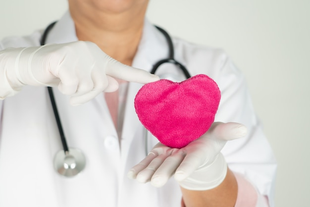 Concept de la journée mondiale de la santé cardiaque et assurance médicale de santé avec médecin avec stéthoscope tenant coeur rouge